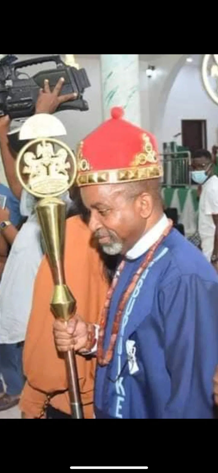 A respected elder in ceremonial attire holding a staff at a Ngwa event.